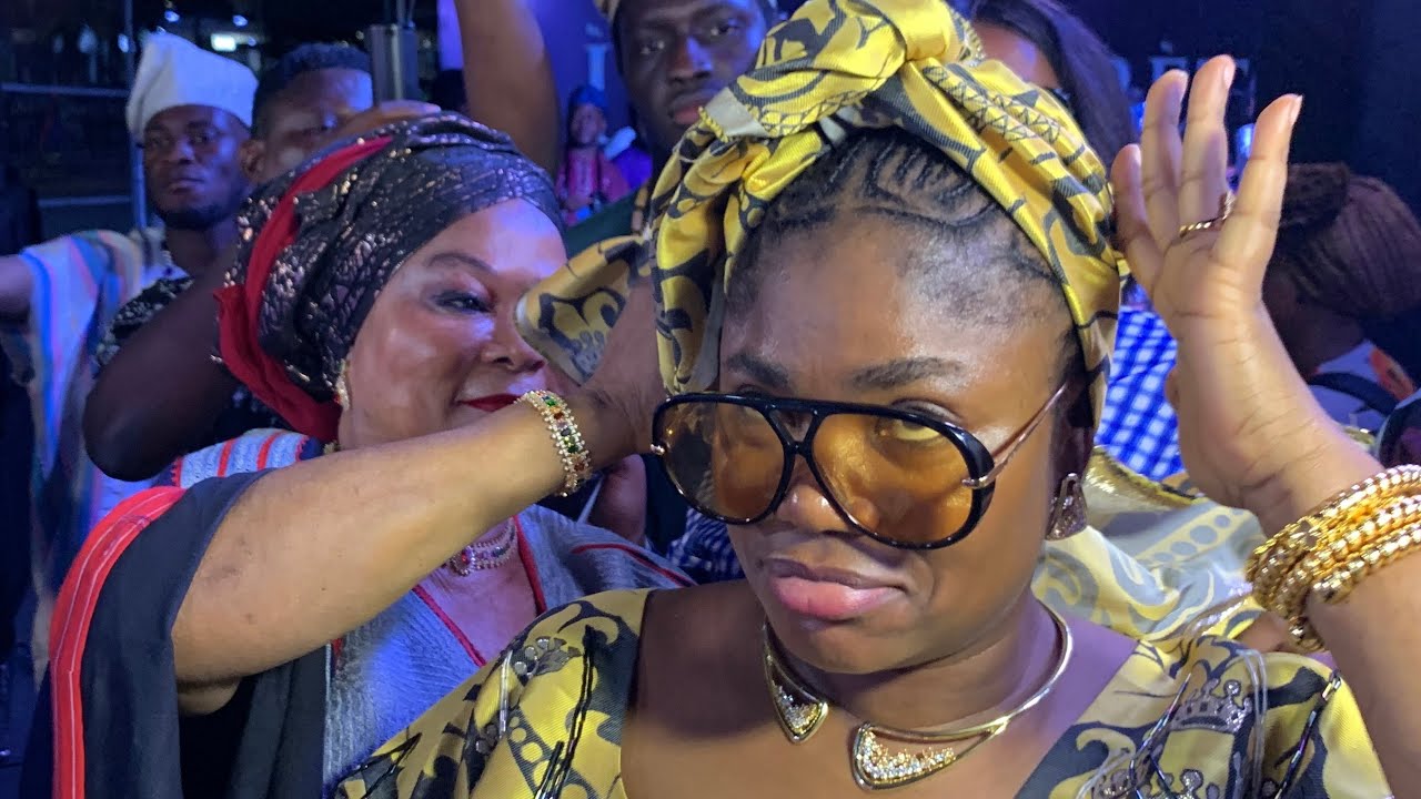 CARING MOTHER! SEE HOW SOLA SOBOWALE HELP ENIOLA AJAO FIX HER GELE WHILE DANCING AT IRETE PREMIERE 