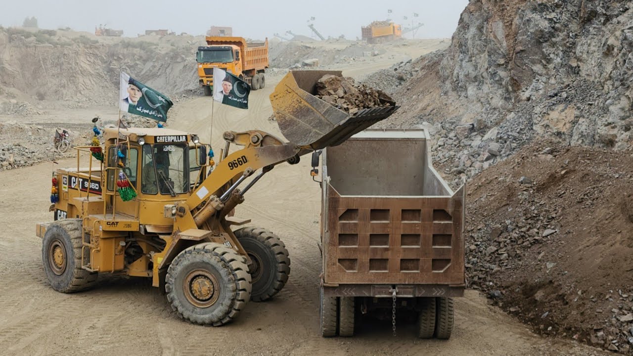 Heavy-duty Machinery in Action: Caterpillar 966D Loading Stone into Dump Trucks