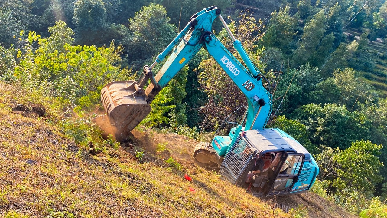 Watch a Kobelco Excavator Master This Risky Mountain Pass Construction