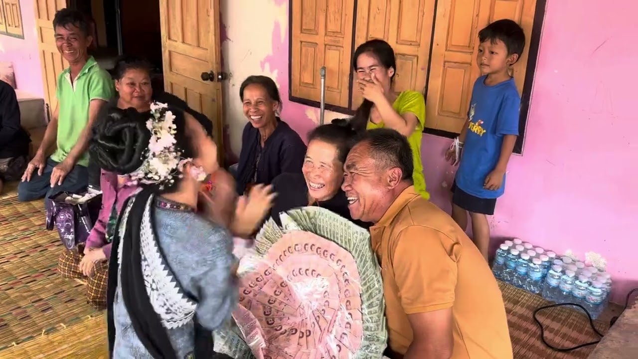 ผู้เฒ่าทำบายศรีสู่ขวัญ้อนาผูกแขนให้น้องธิดาลาว