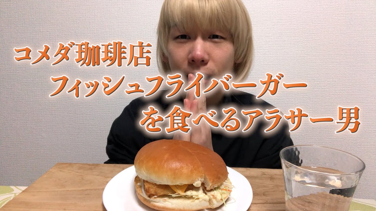 Мужчина ест бургер с рыбой и жареной картошкой в ​​кафе Komeda Coffee.