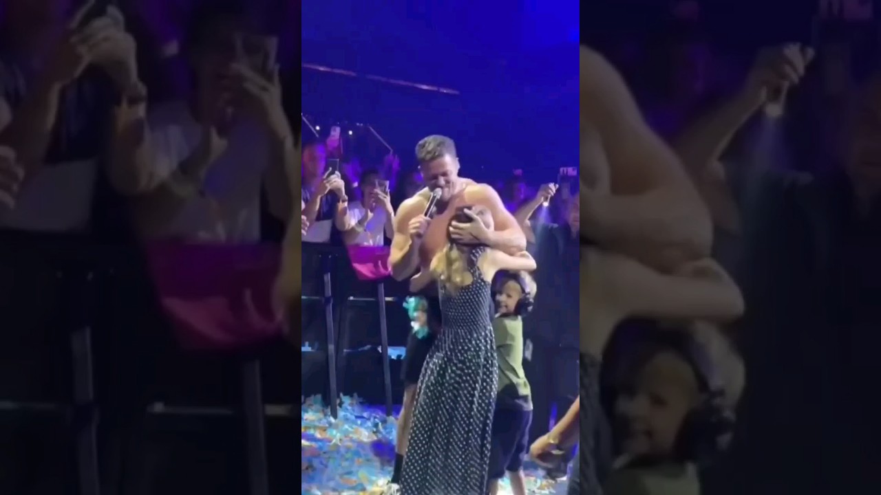 Dan Reynolds hugs his daughters Arrow and Coco during singing 