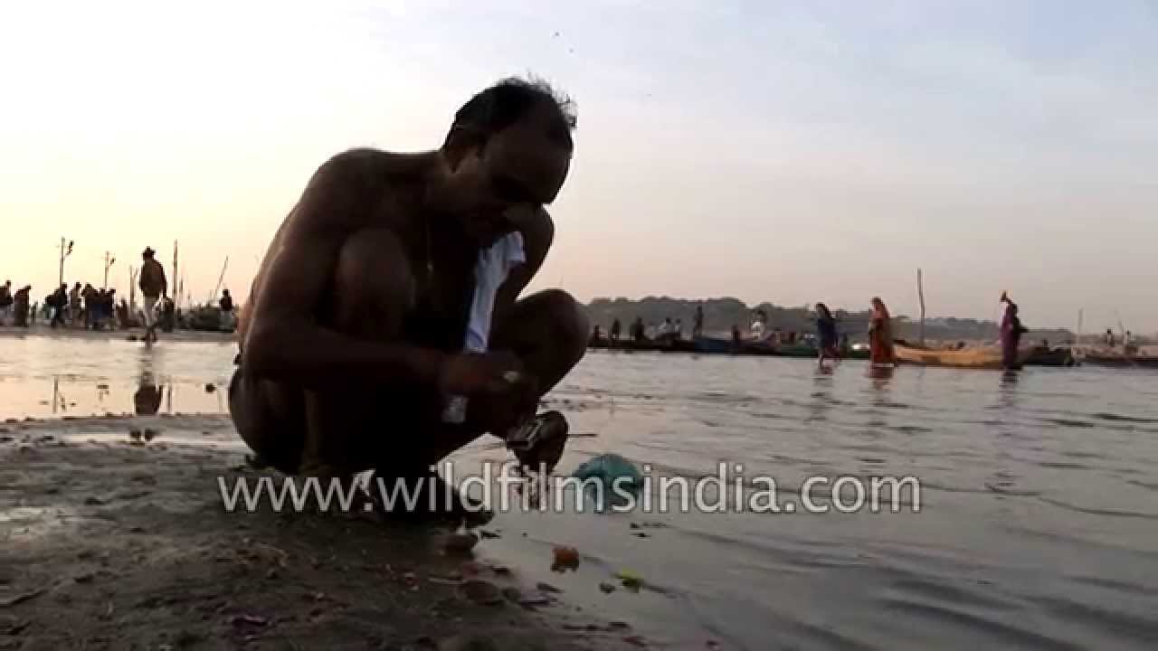 Man lights diya as offering to Ganga River - Kumbh Mela