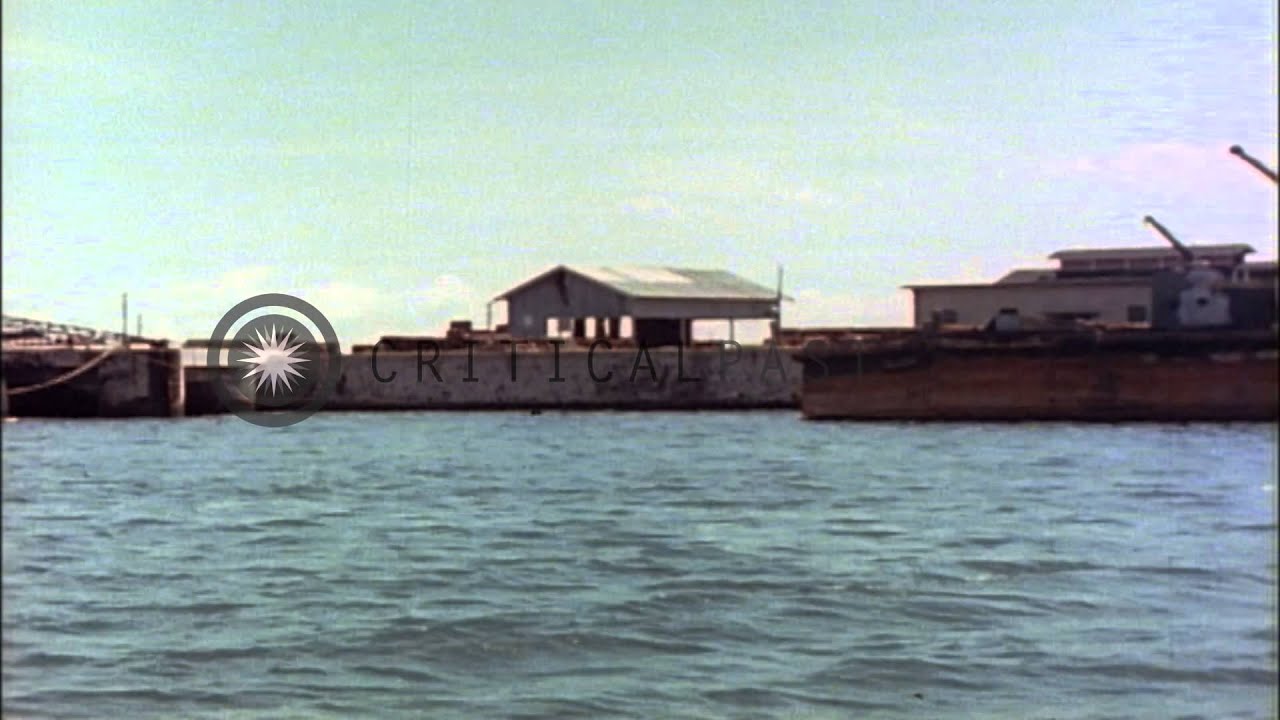 A small Japanese tanker tied alongside a pier and Japanese battleship Nagato anch...HD Stock Footage
