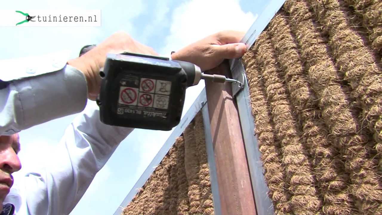 Kokos schutting met houten palen plaatsen - Tuinieren.nl
