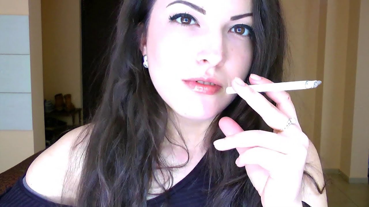 Beautiful brunette smokes an all-white cigarette