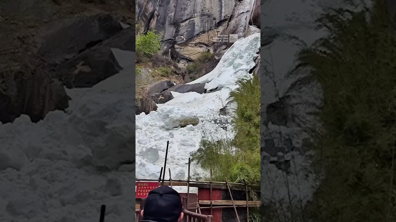 Tourists run as giant snowball barrels down hill
