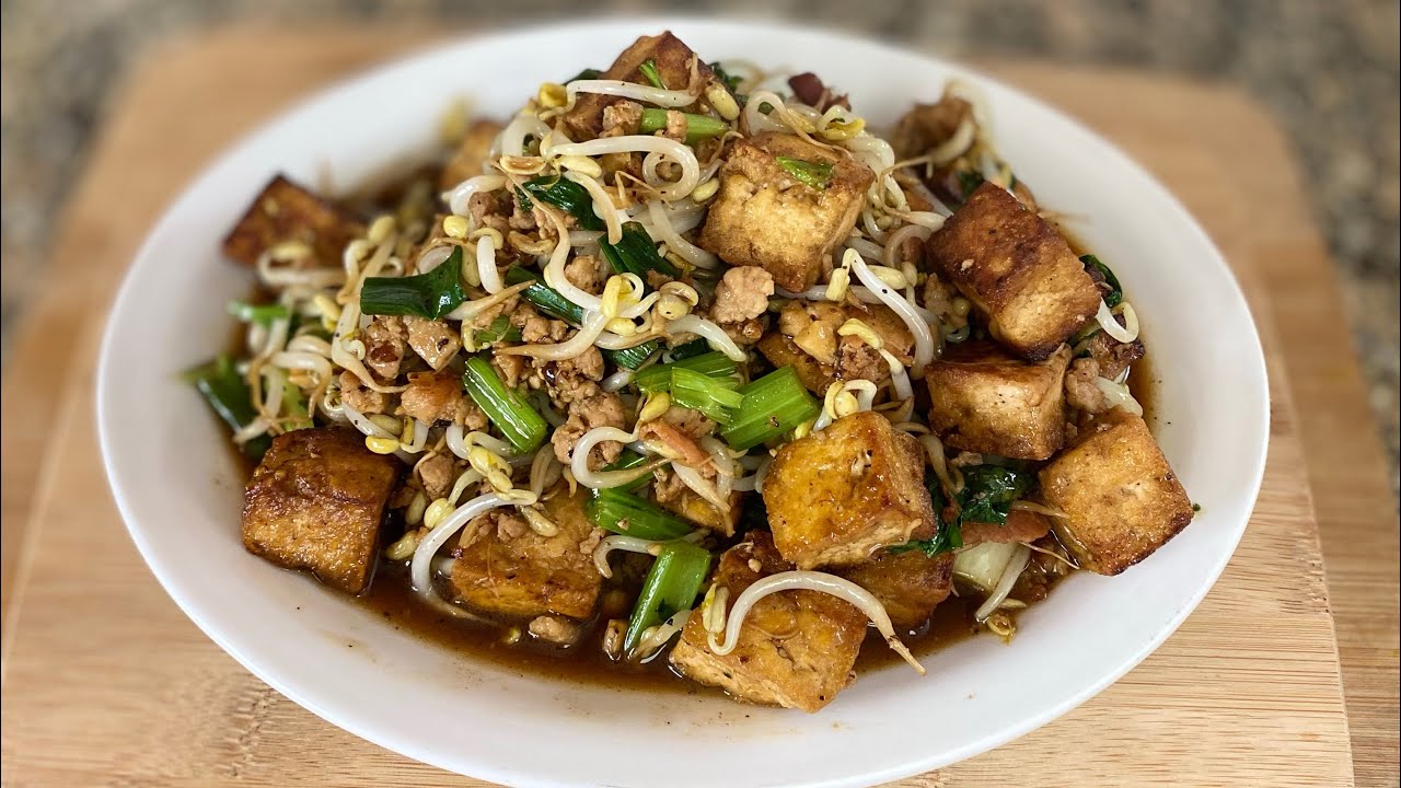 Stir fry tofu with bean sprouts and ground pork .