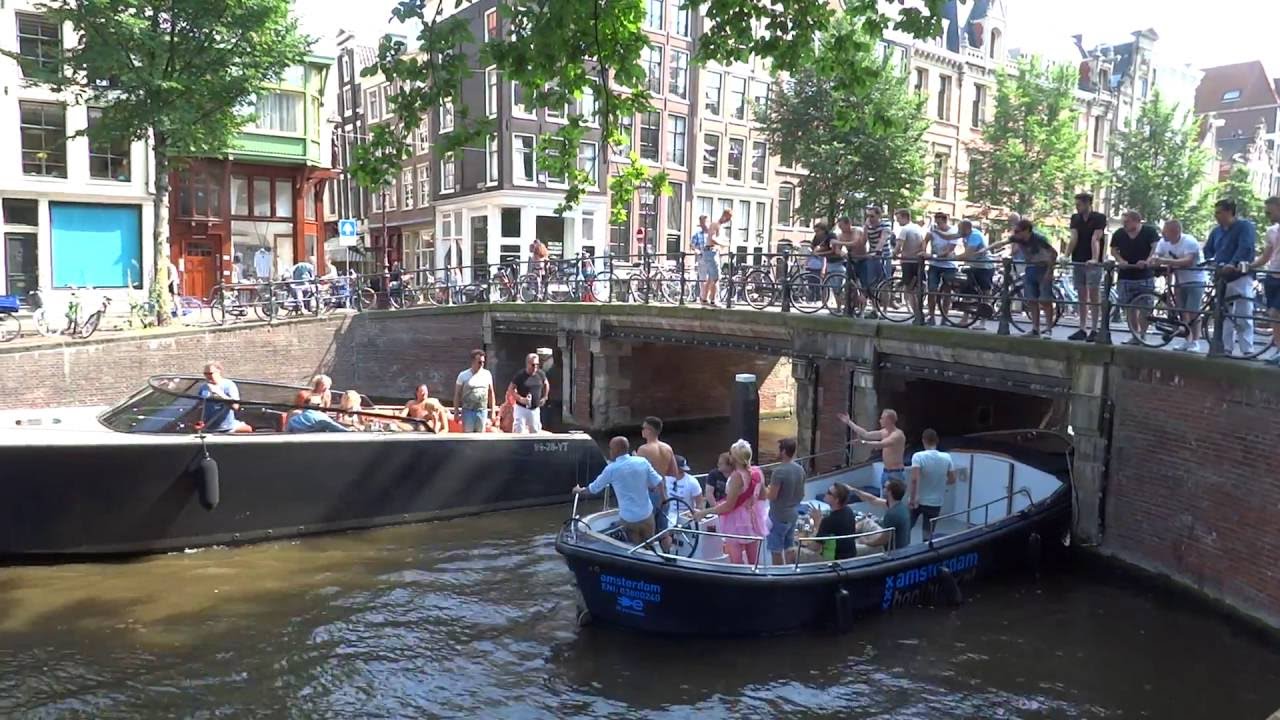 Chaos op Grachten Amsterdam: Sloep zit muurvast onder de brug