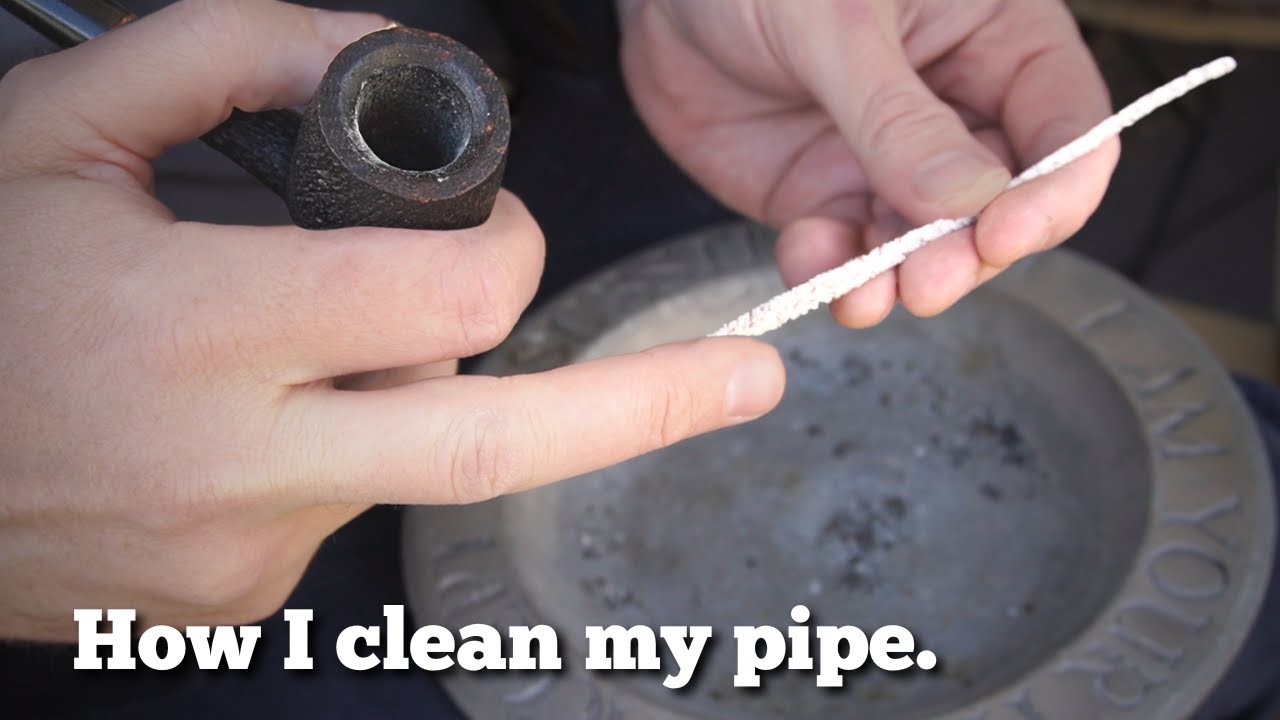 A man shows how he cleans his pipe