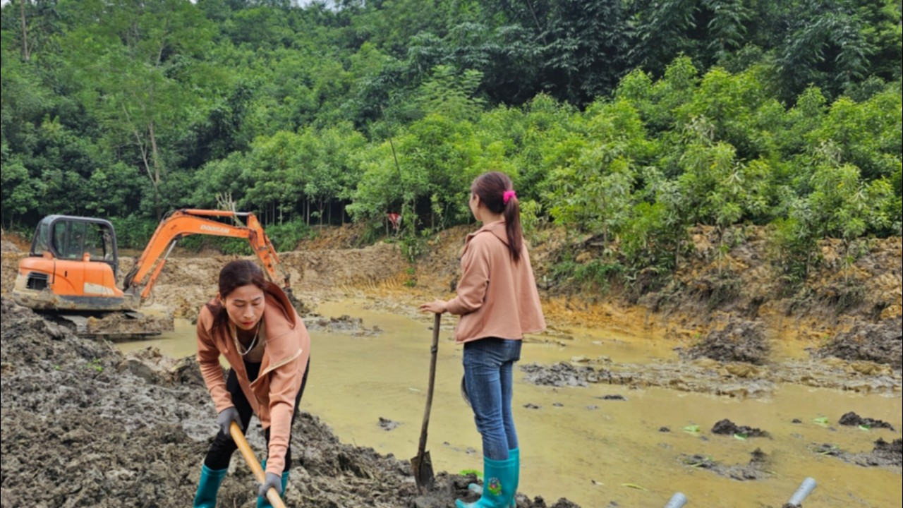 FULL VIDEO: Overview of an excavator digging soil for rice paddies and fish ponds.